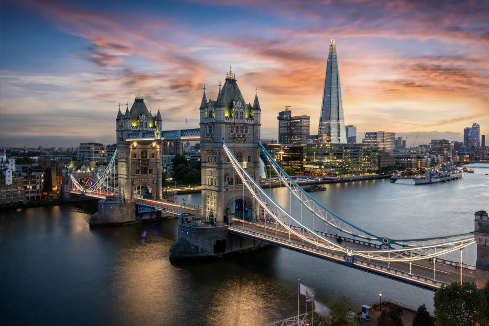 Widok z lotu ptaka na podświetlony Tower Bridge i panoramę Londynu, Wielka Brytania, tuż po zachodzie słońca