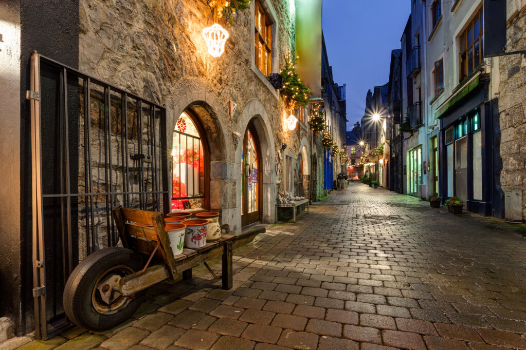 Stara ulica w Galway, Kerwana Lane, ozdobiona lampkami świątecznymi, scena nocna