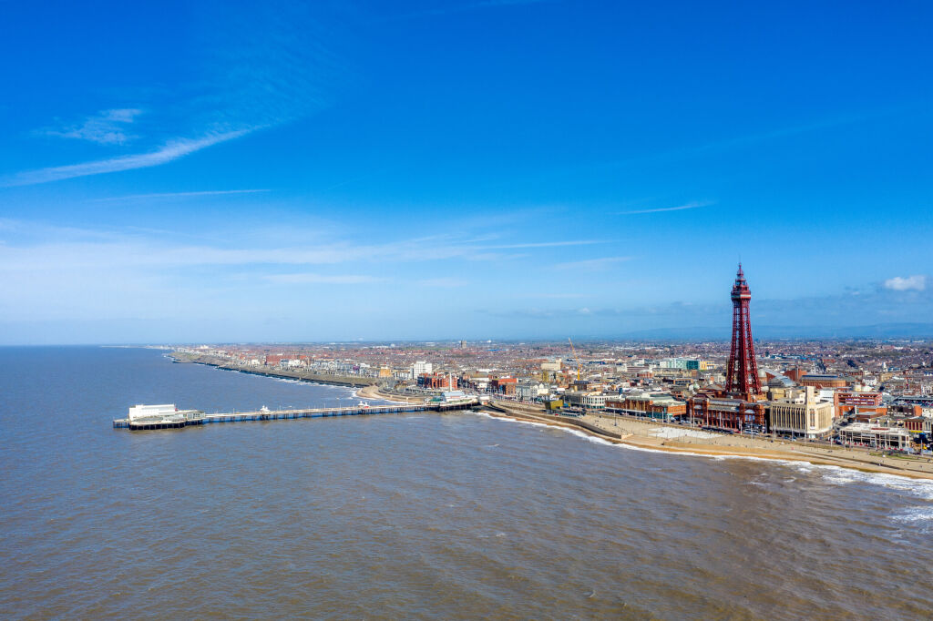 Aerial footage, drone view , of the famous Blackpool Tower and beach from the sky on a beautiful Summers day on one of Great Britains most popular holiday destinations, tourist attractions by the sea