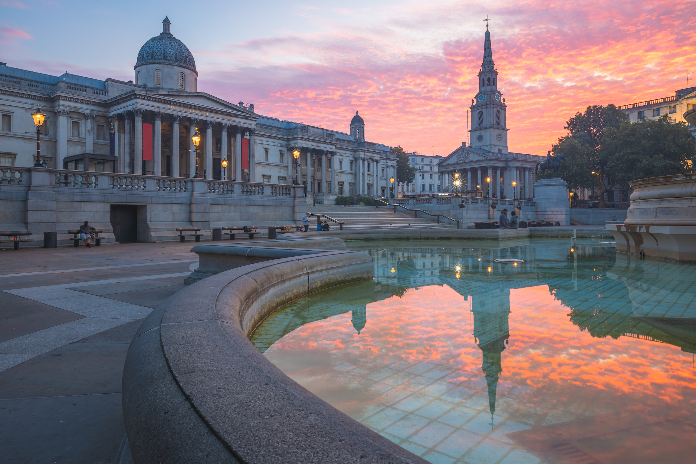 Żywe, kolorowe, dramatyczne niebo o wschodzie lub zachodzie słońca na Trafalgar Square i National Gallery w centrum Londynu, Wielka Brytania.