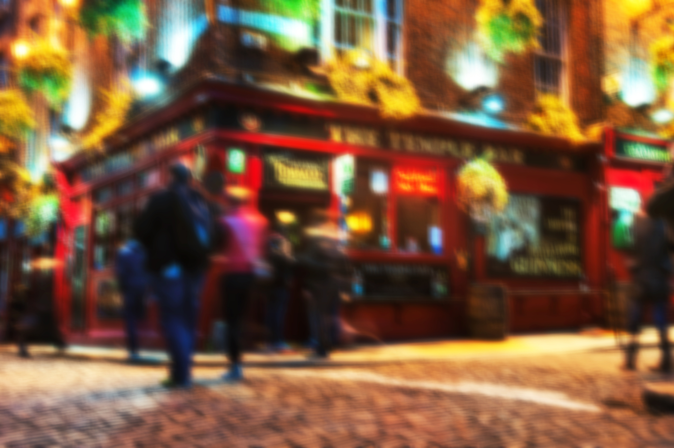 Rozmyte tła z podróży - Życie nocne w popularnej historycznej części Dublina w Irlandii - dzielnicy Temple Bar.W okolicy znajduje się wiele barów, pubów i restauracji. Ludzie spacerujący wewnątrz pubu