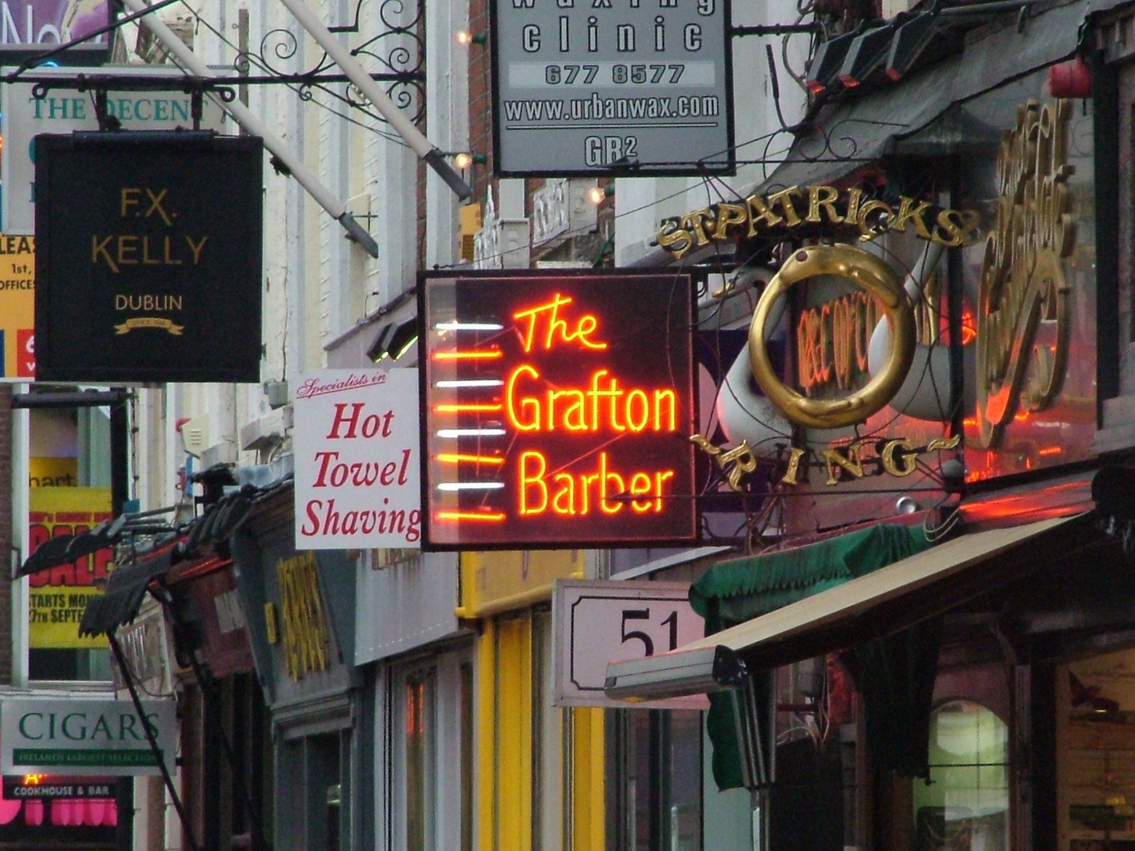 Neony na Grafton Street. Różne znaki uliczne na Grafton Street w Dublinie