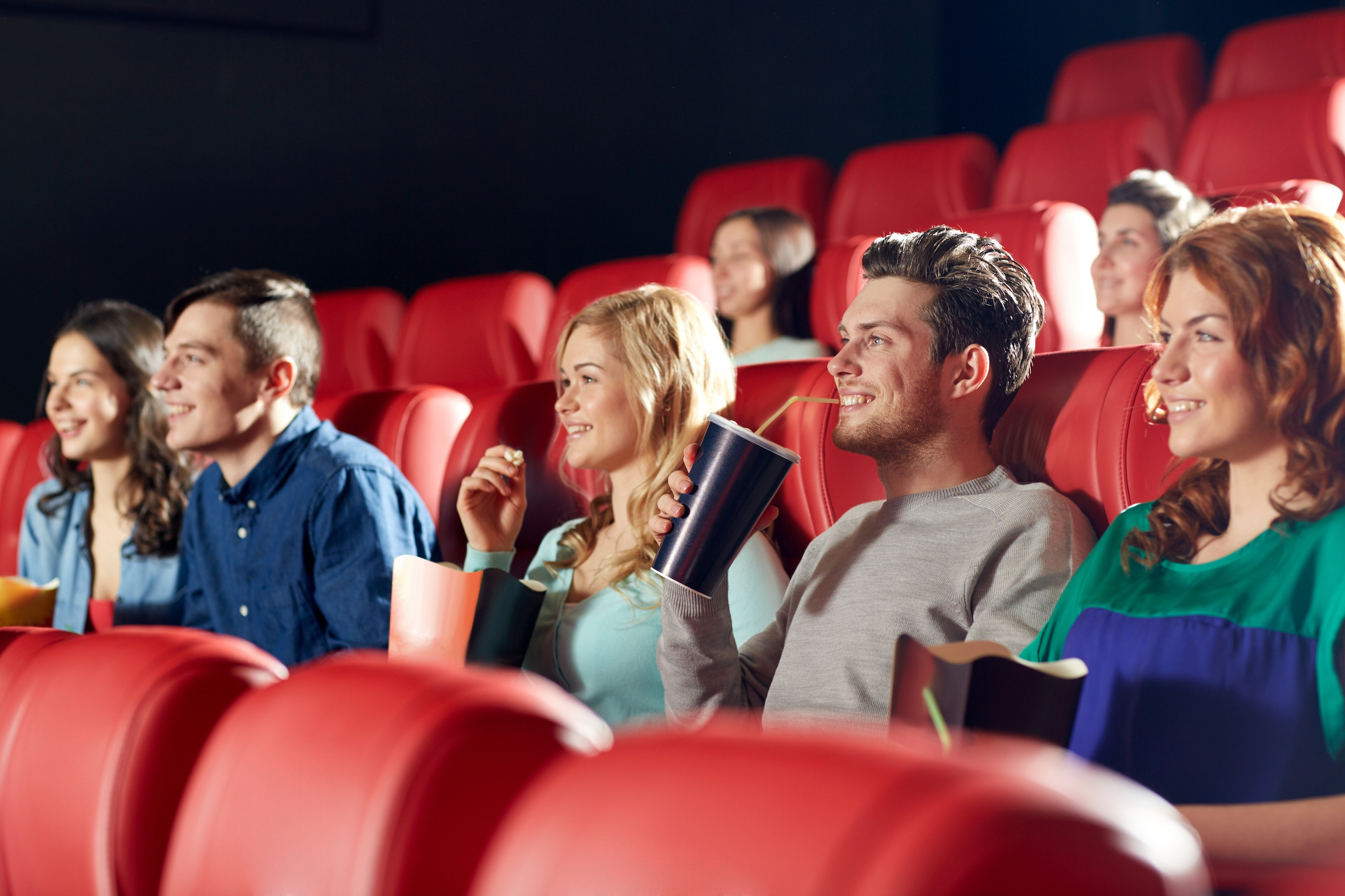 kino, rozrywka i ludzie koncepcja - szczęśliwi przyjaciele oglądający film w teatrze