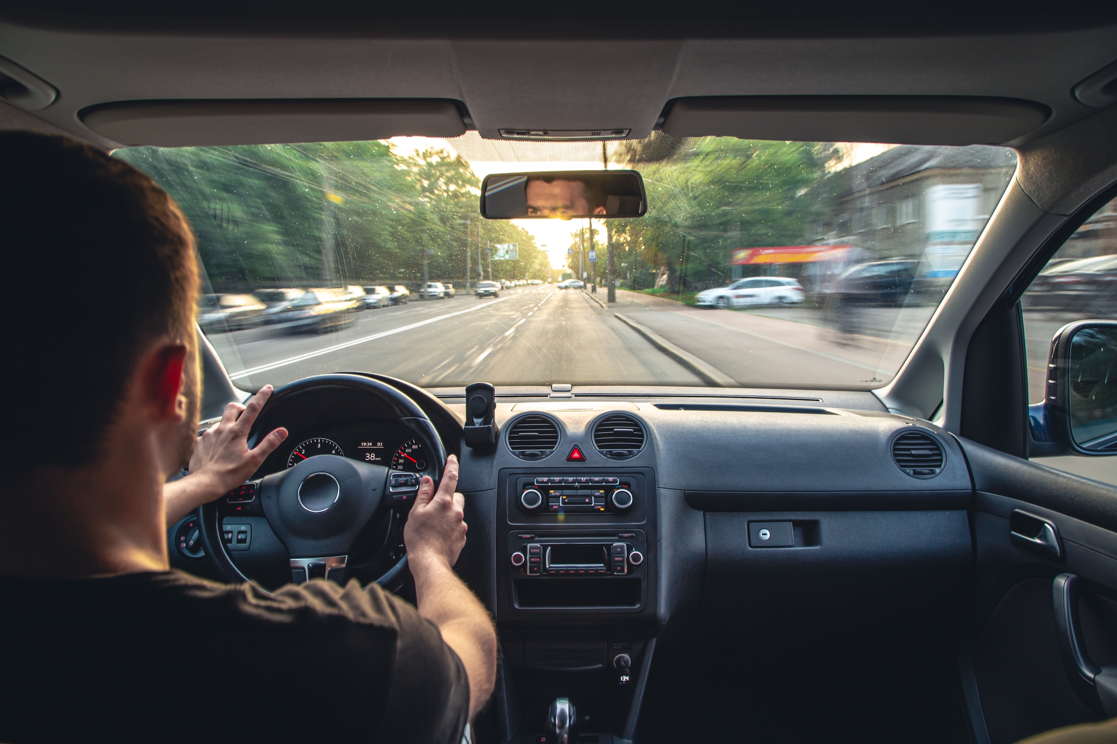 Ręce na kierownicy podczas jazdy z dużą prędkością z wnętrza samochodu.
