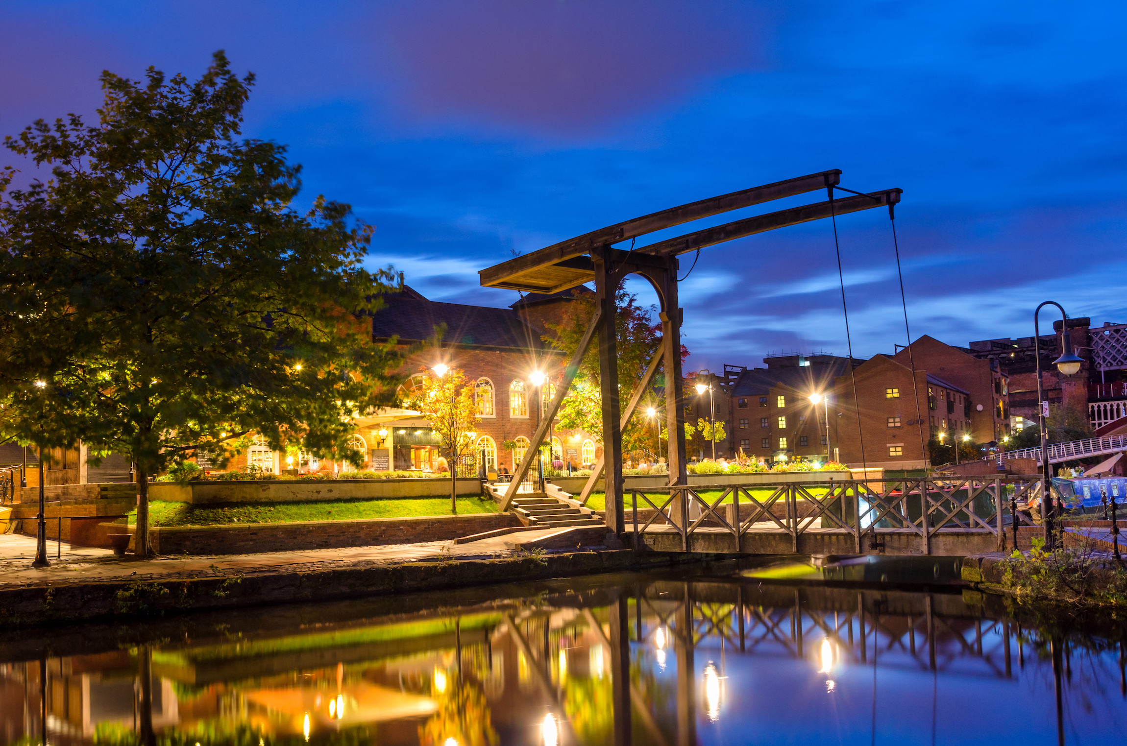 Stary drewniany most zwodzony w historycznym Castlefield nocą. Manchester, Wielka Brytania.