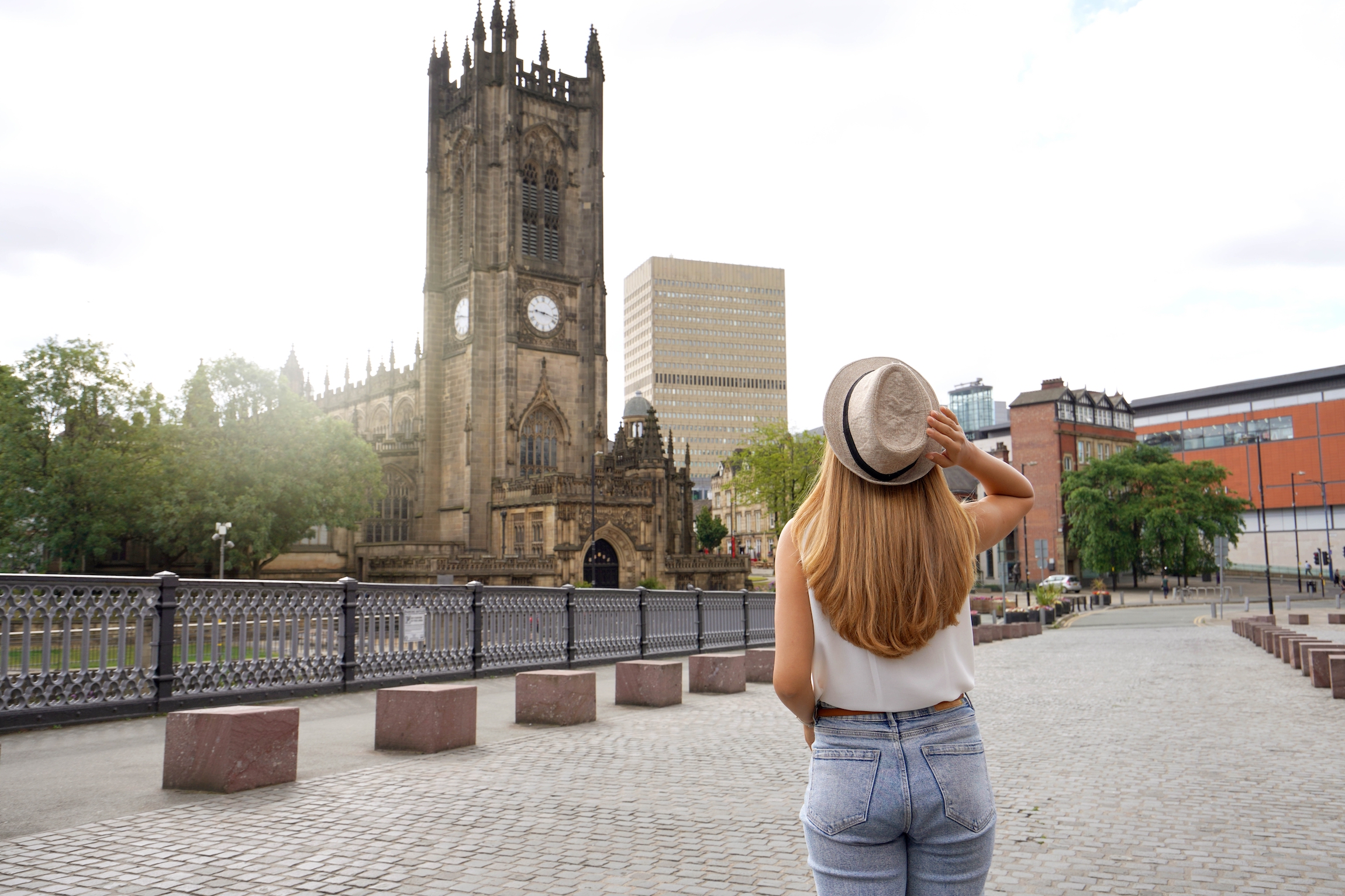Widok z tyłu pięknej blondynki w kapeluszu spaceru po Manchesterze w słoneczny dzień, Anglia, Wielka Brytania